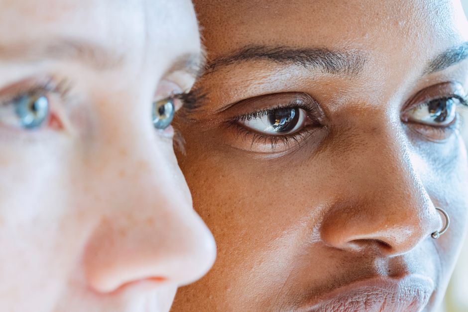A close-up view highlighting the diverse skin tones and facial features of two women, showcasing beauty and diversity.