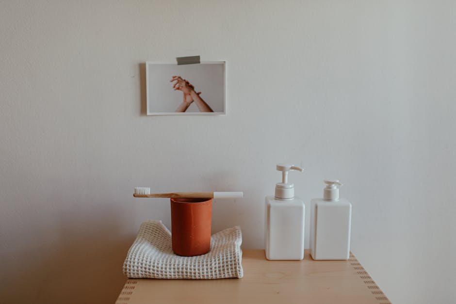 Minimalist bathroom setup with toothbrush, cup, and soap dispensers on wooden dresser.