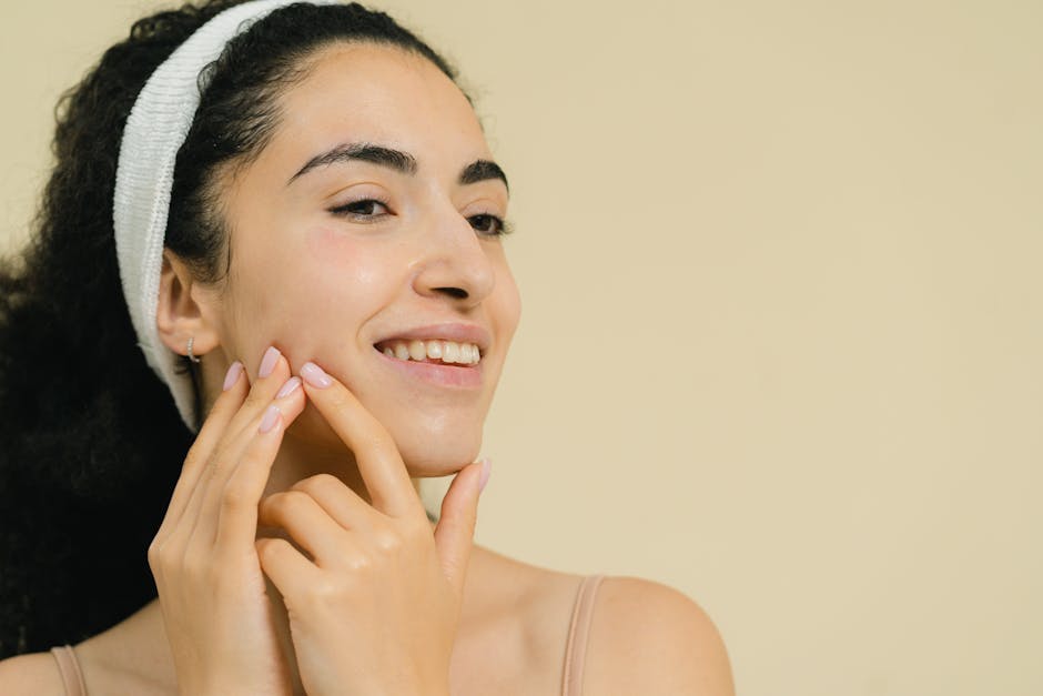 Close-up of a smiling woman applying skin treatment, promoting natural beauty and skincare.