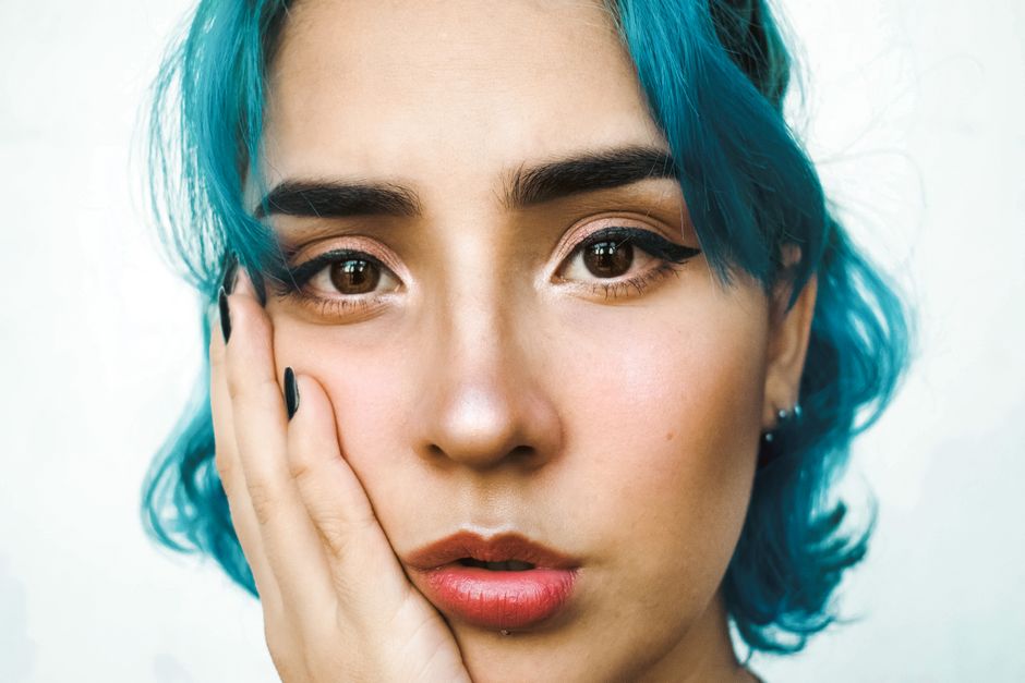 Stunning portrait of a young woman with blue hair and natural makeup.