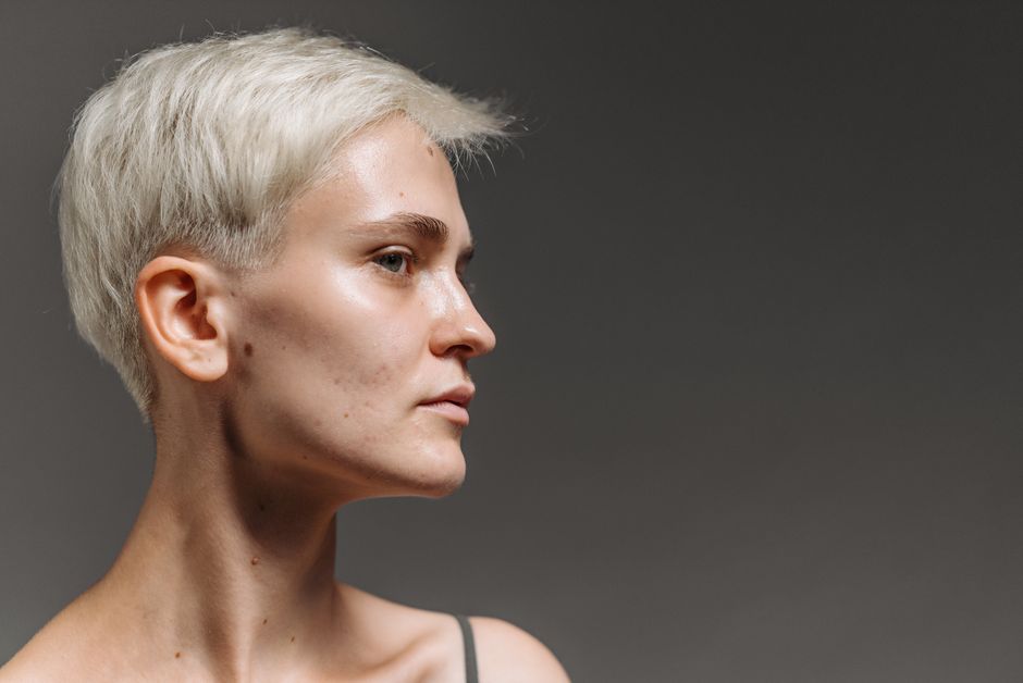 Side view profile portrait of a caucasian woman with short white hair.