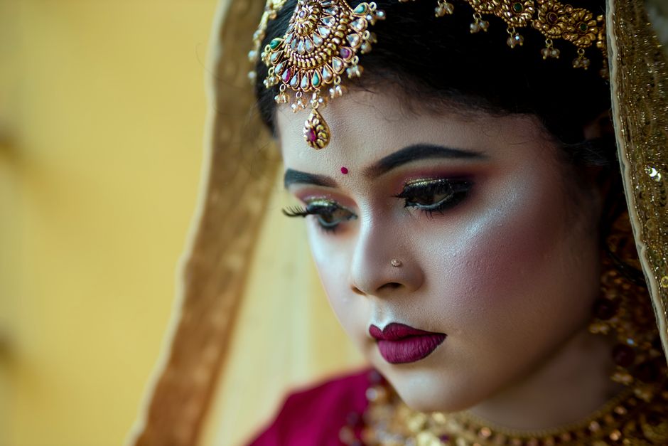 Close-up of a bride with traditional jewelry and makeup, showcasing elegance and beauty.