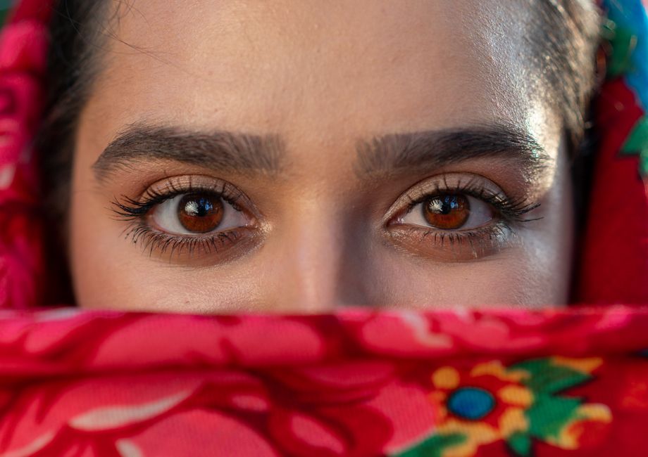 A close-up image focusing on expressive eyes framed by a vibrant floral scarf.